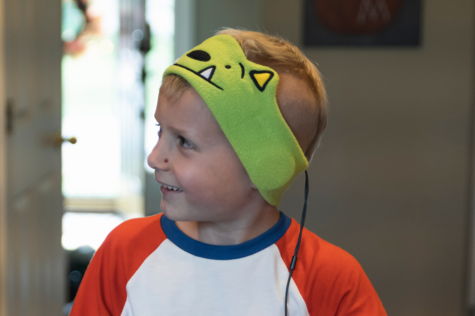 A smiling child wearing headband-style headphones.