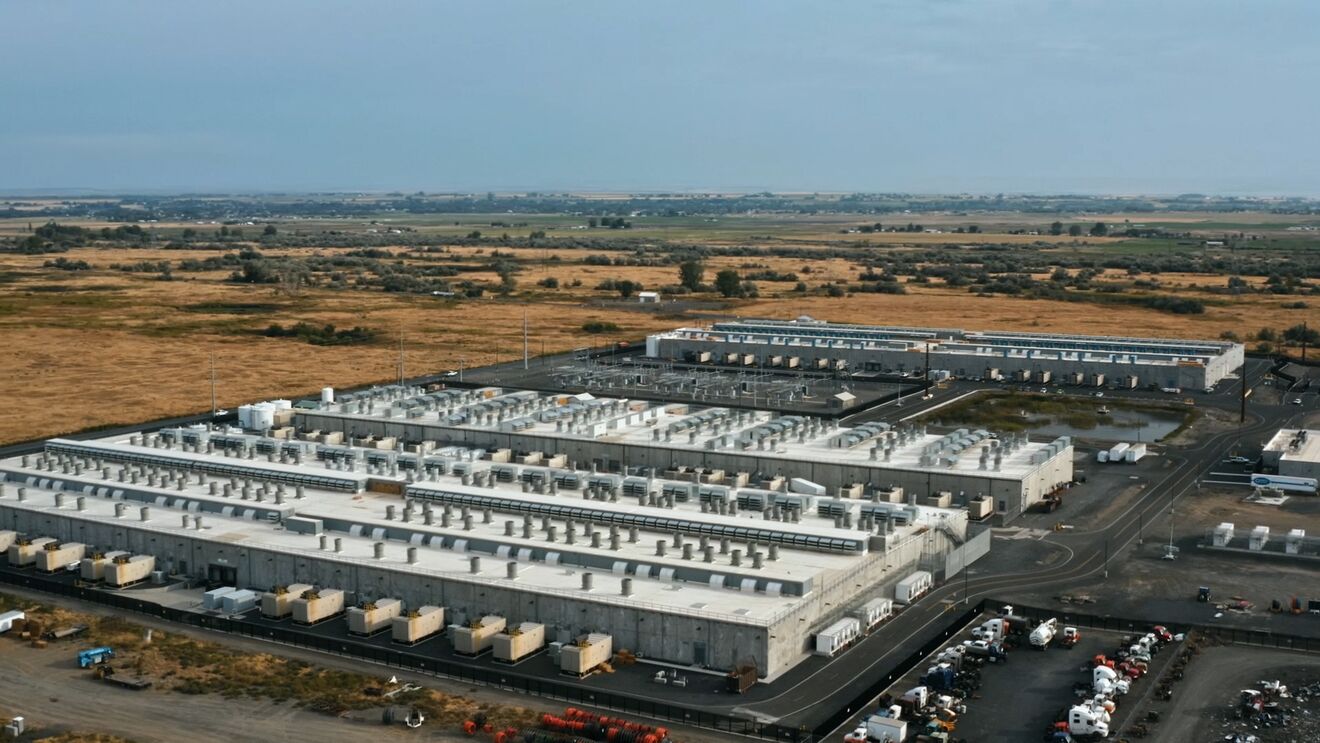 Aerial view of data center facility surrounded by dry fields