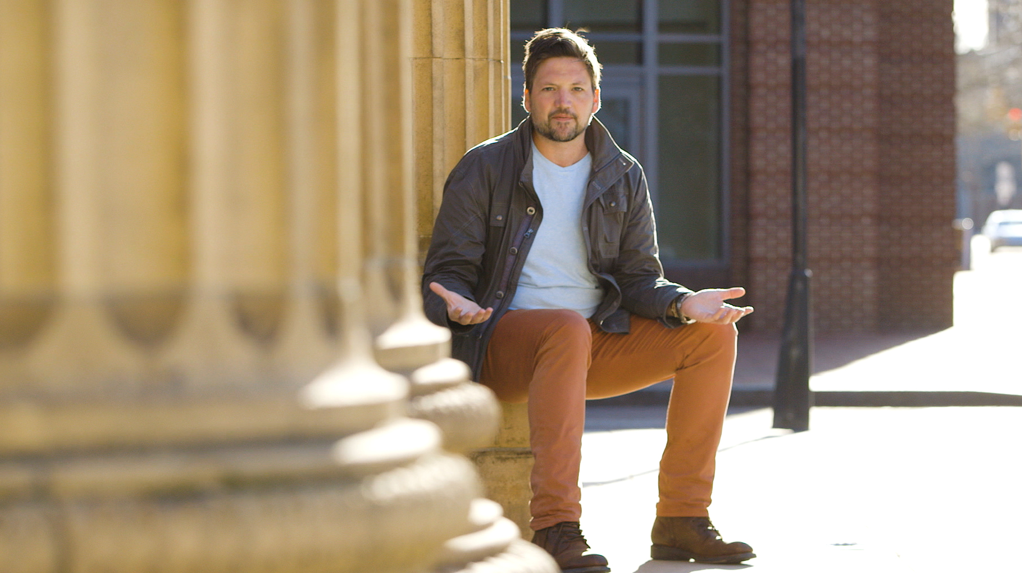 AWS Startup Evangelist Mackenzie Kosut sitting against a wall
