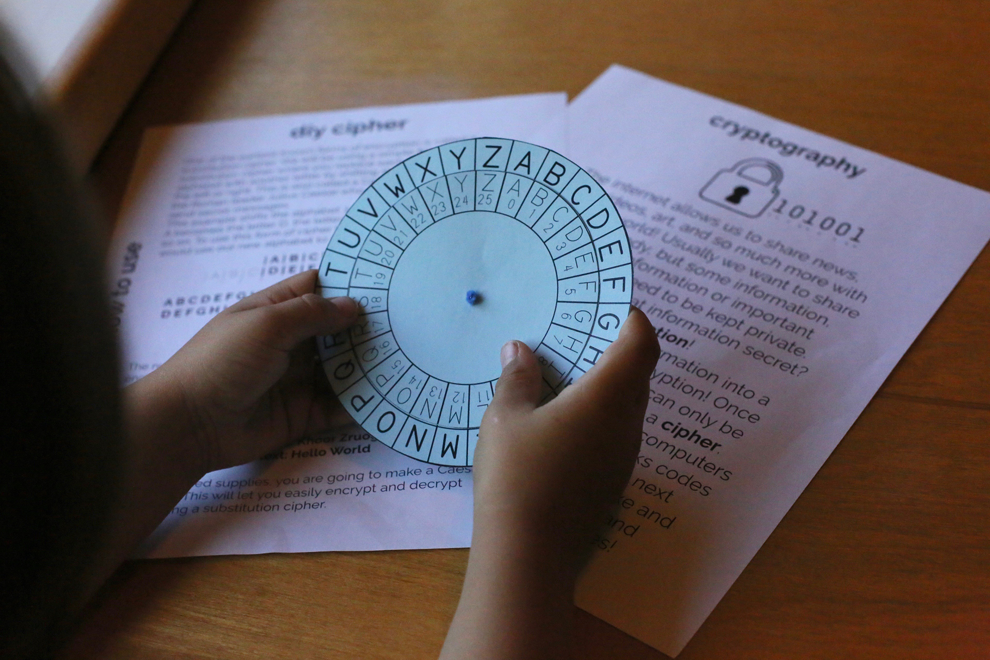 A student holds a paper cypher in his hand, as he learns about STEM education.