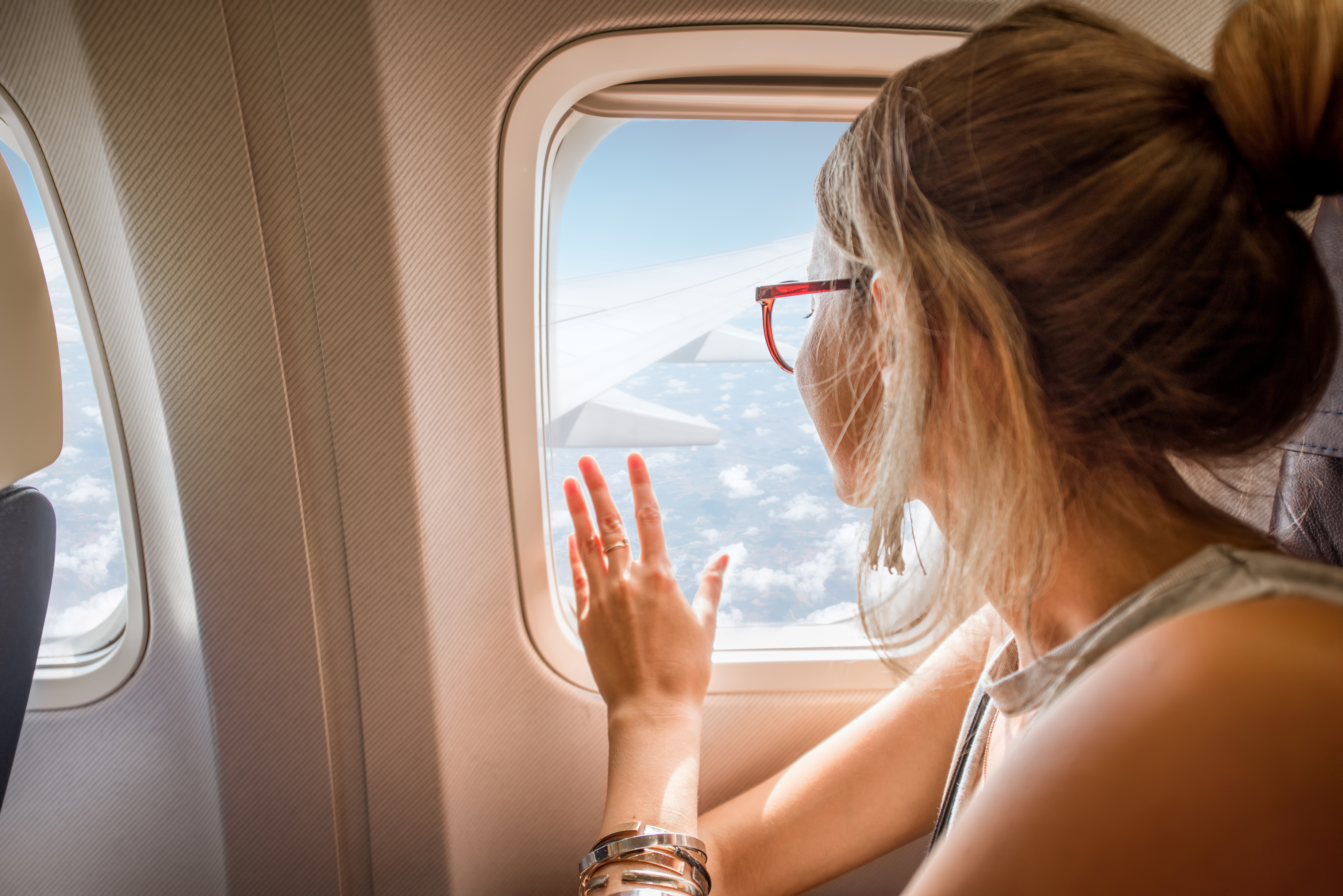 A woman looks out of the airplane.