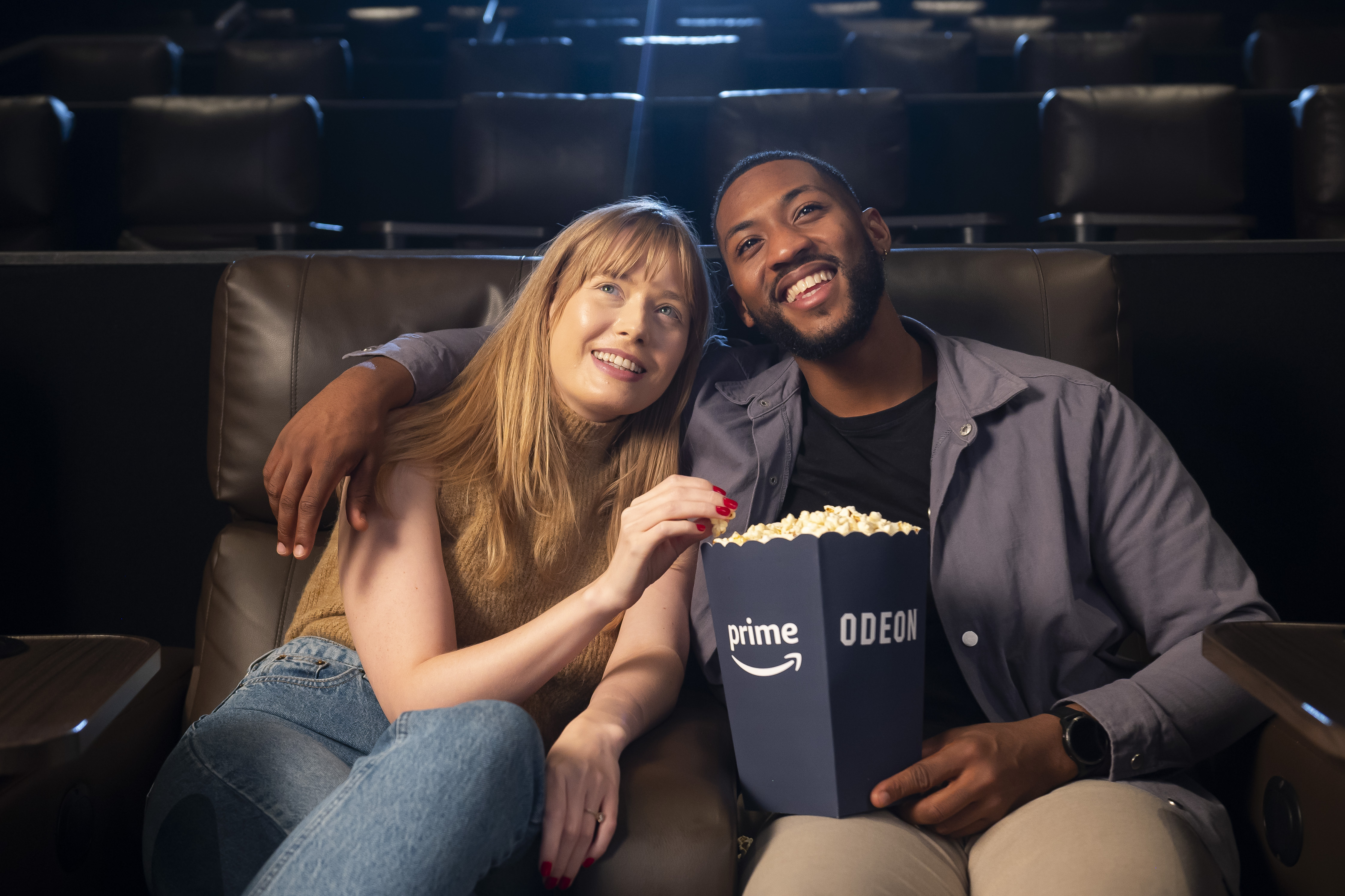 A woman and a man enjoy date night on Amazon Prime and Odeon