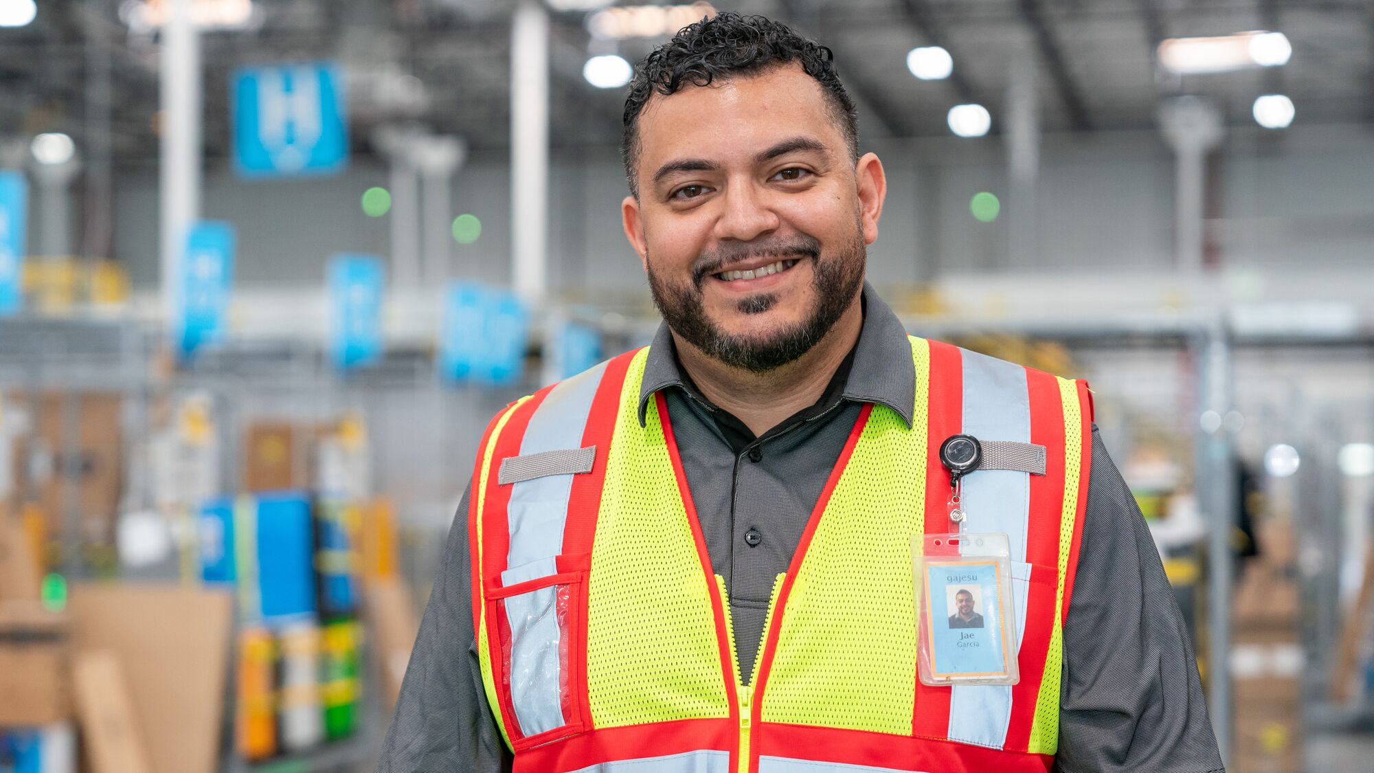 Amazon employee in a fulfillment center wearing a yellow safety vest