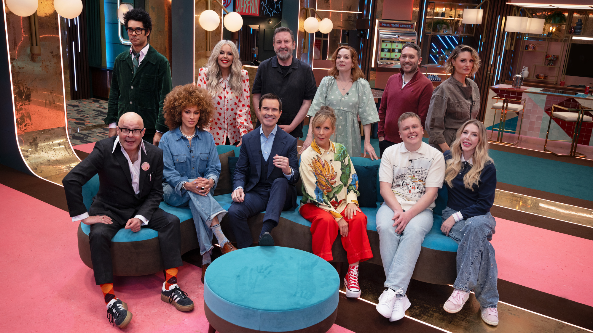 Lee Mack, Katherine Ryan, Harry Hill, Katherine Parkinson, Michelle de Swarte, Jon Richardson, Morgana Robinson, Josh Jones, Richard Ayoade, Mel Giedroyc, and Jimmy Carr sit on the Last one Laughing season 3 set.