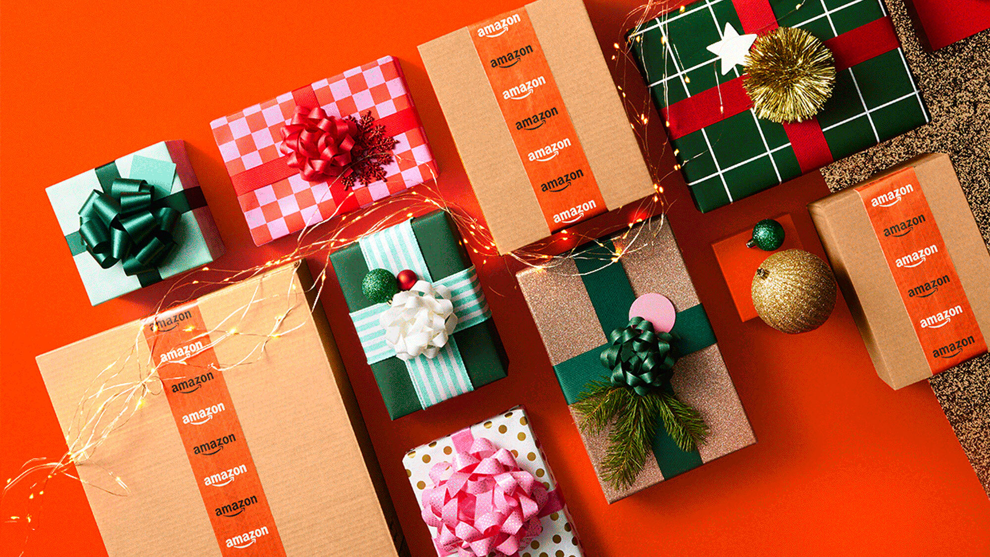 An image of wrapped holiday presents with Christmas lights. There is an orange background behind them.