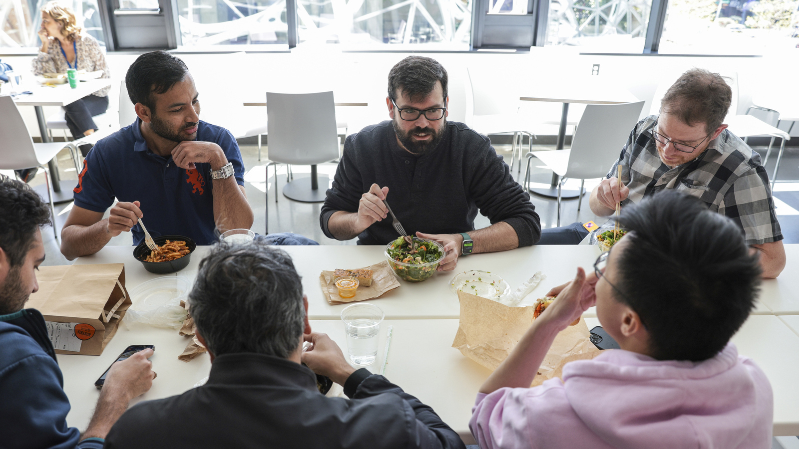 Six Amazon employees eat lunch in the Day 1 cafeteria.