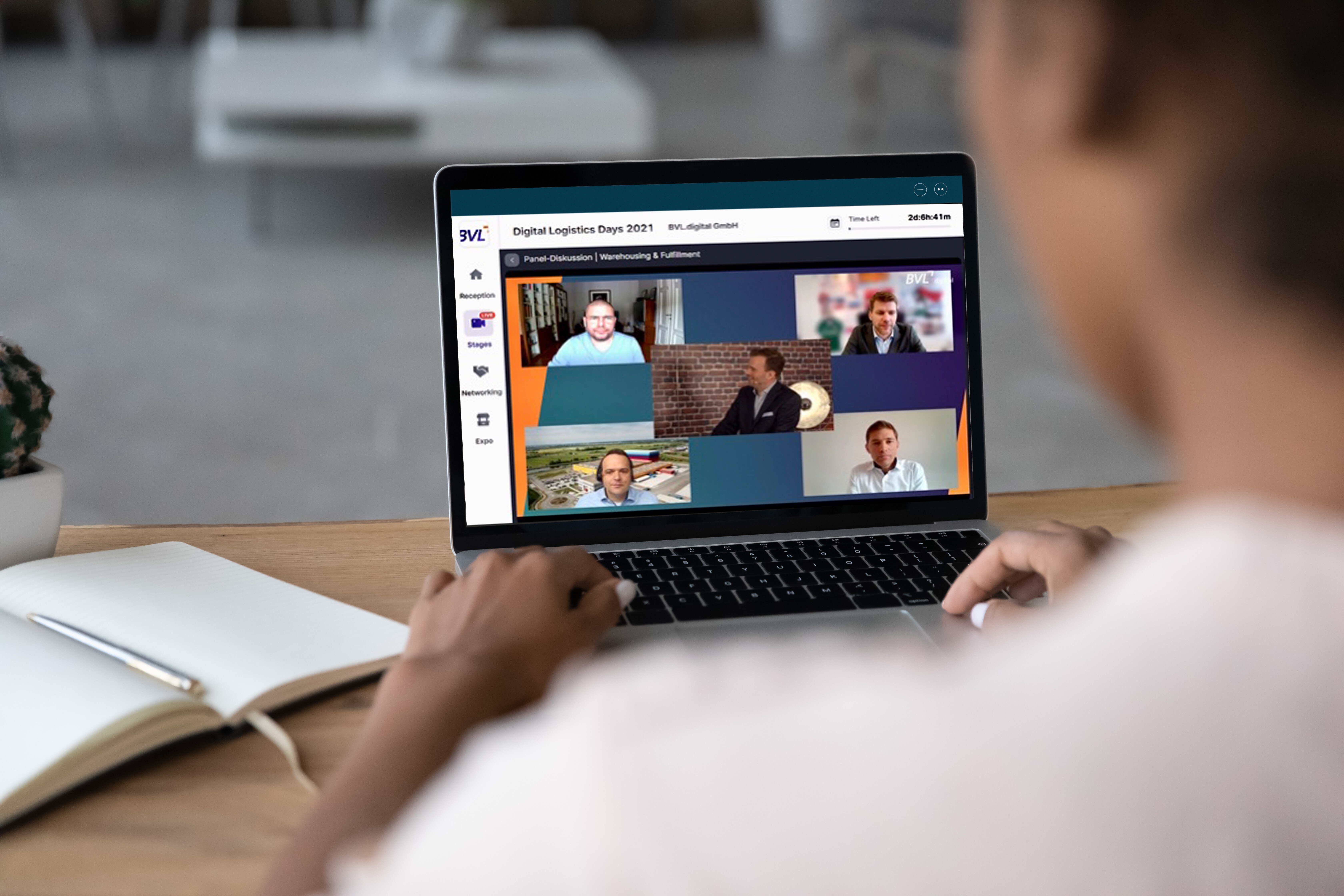 Eine Person, von hinten erkennbar, sitzt vor einem aufgeklappten Laptop. Auf dem Screen die Protagonisten der BVL Videokonferenz.
