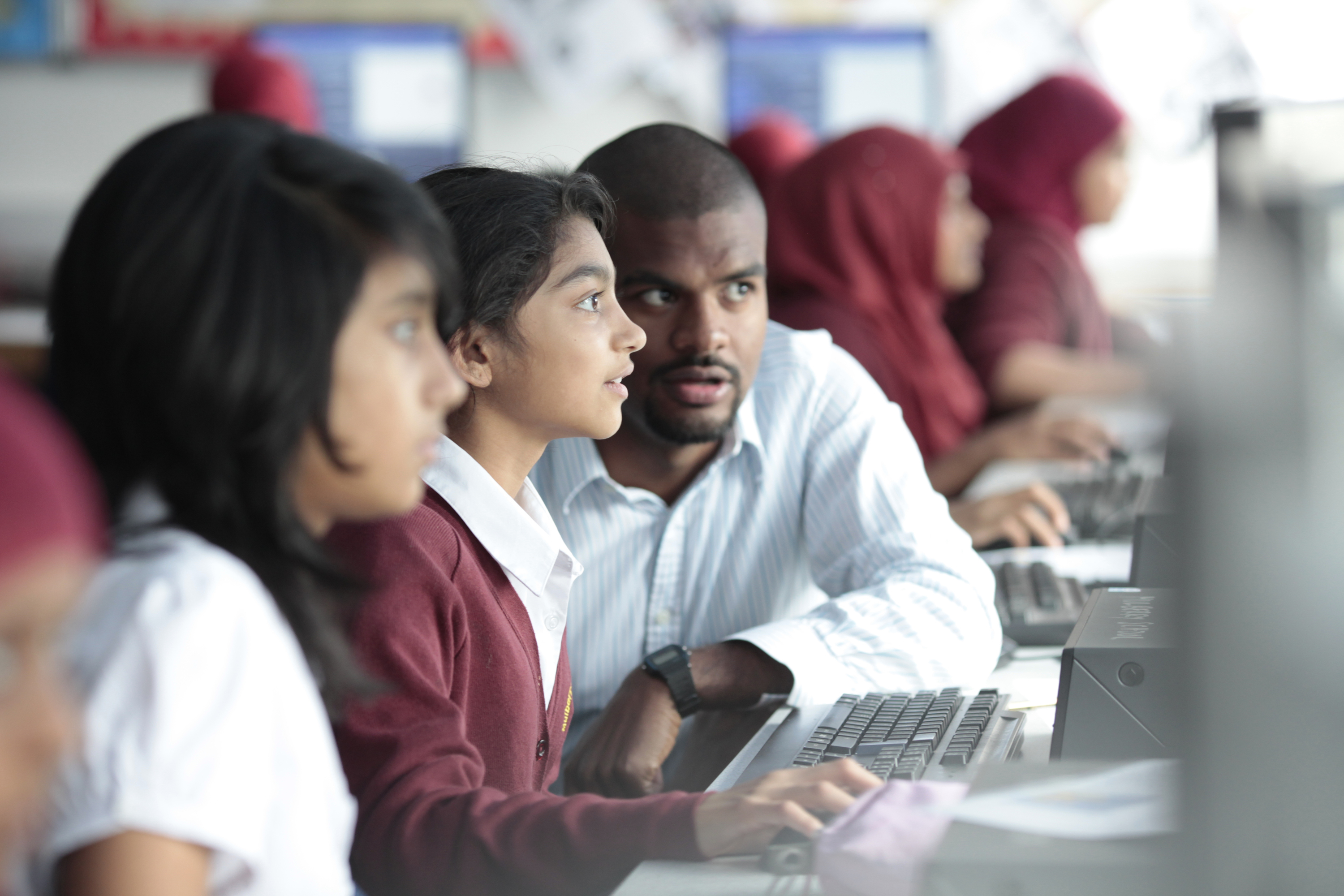 Students from Mulbury School having an IT lesson, a teacher is helping a student.