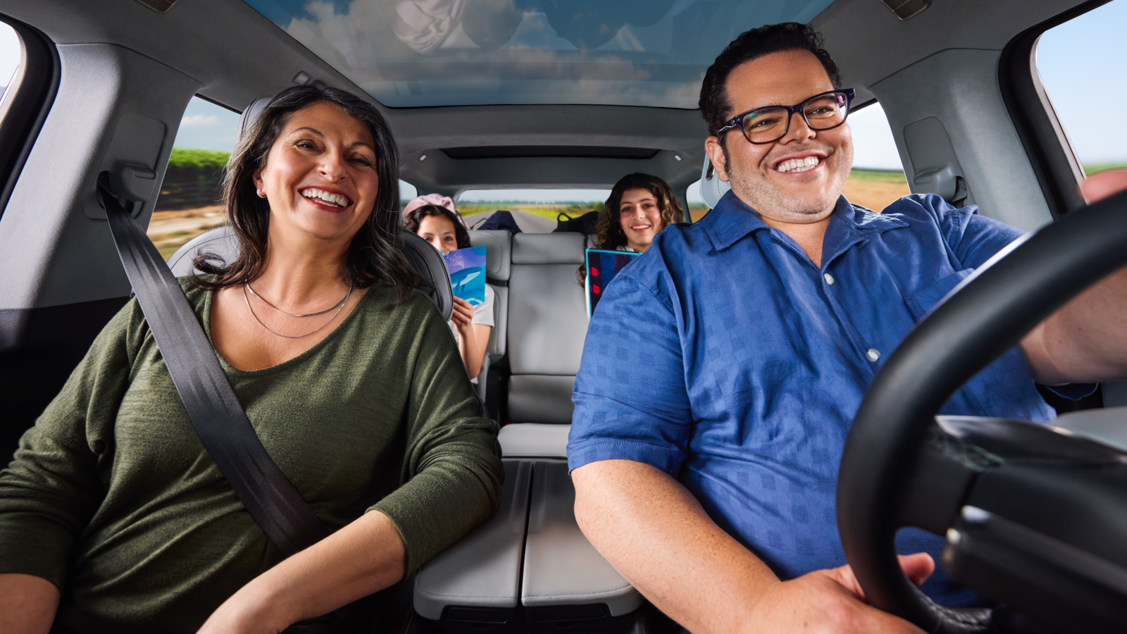 Family smiling together during car ride on sunny day