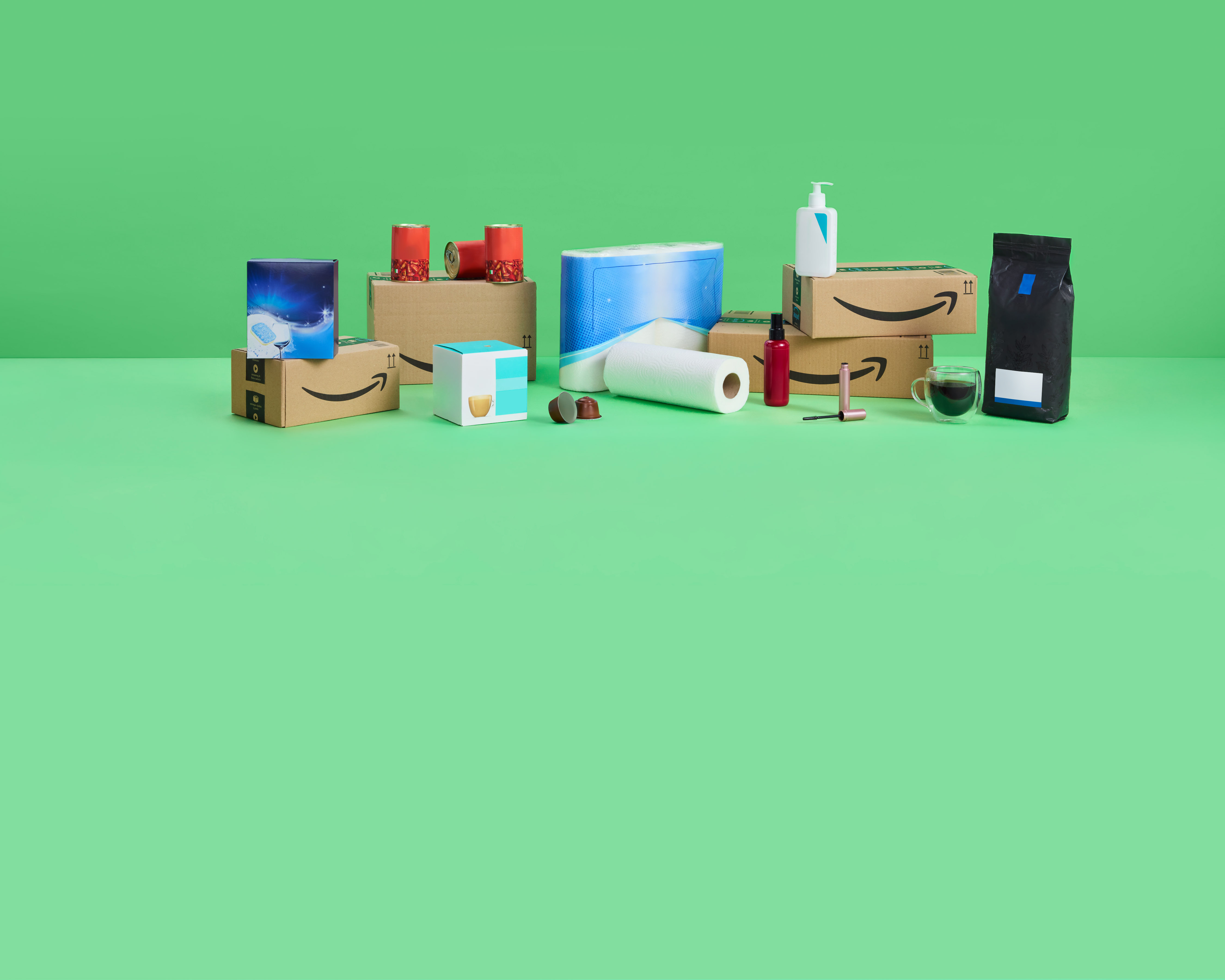 Amazon-Lieferung mit Alltagsprodukten und Lebensmitteln auf grünem Hintergrund