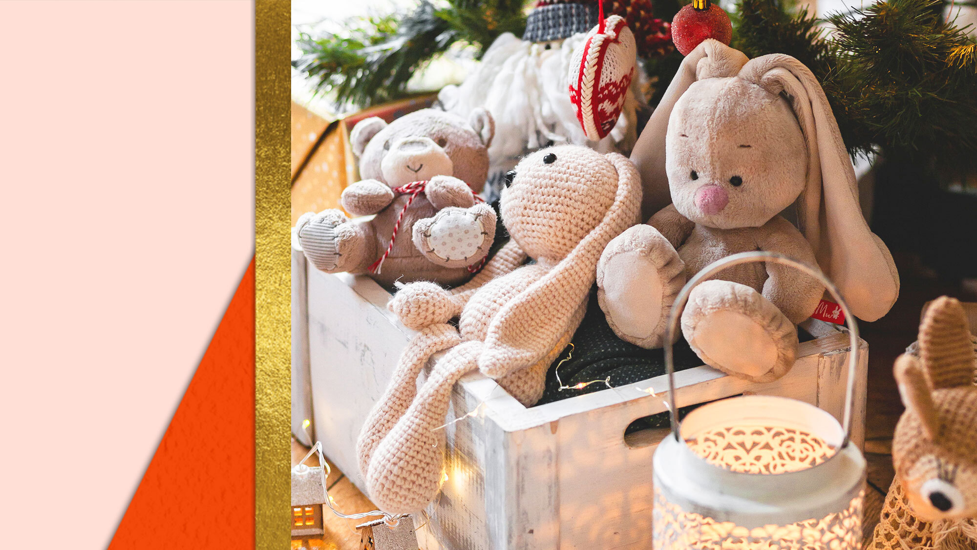 Toys including a stuffed bear and stuffed bunnies in a wooden crate under a Christmas tree.