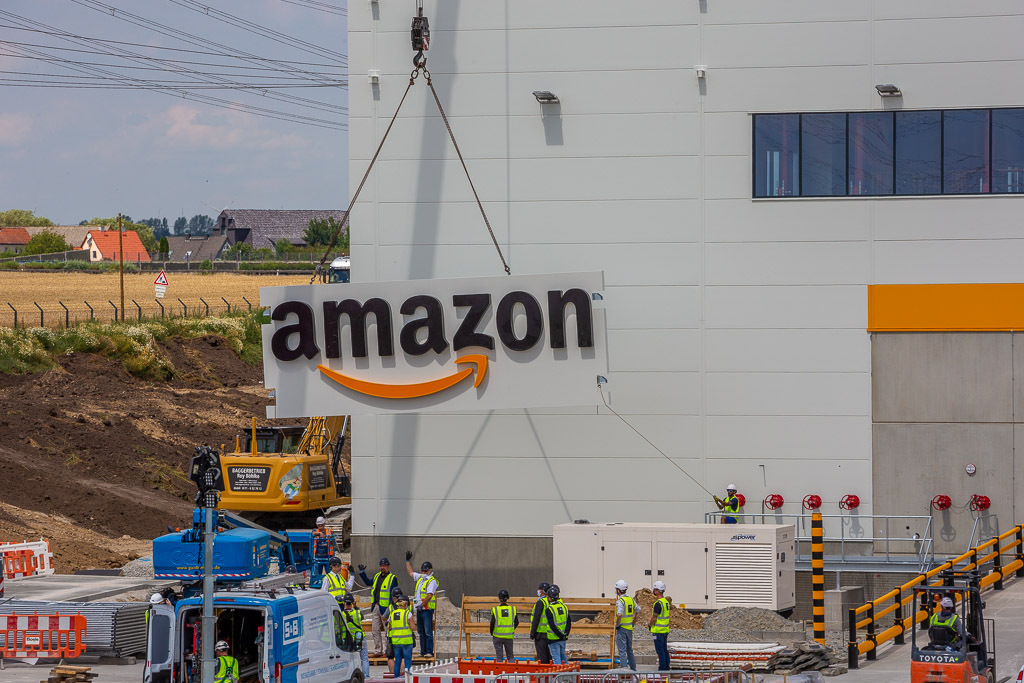 Das Amazon  Logo wird per Kran am Außengebäude angebracht.