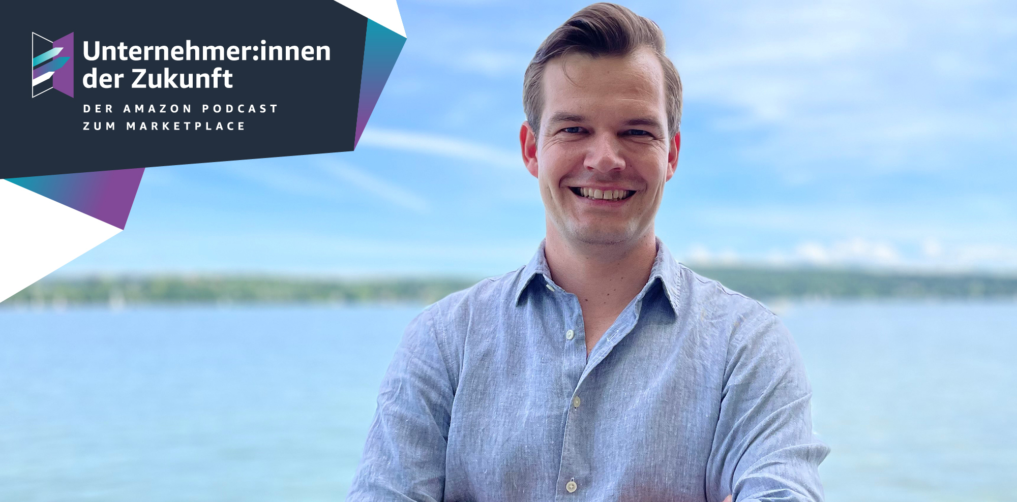Ein Mann mit blonden Haaren und einem hellblauen Hemd lacht in die Kamera.