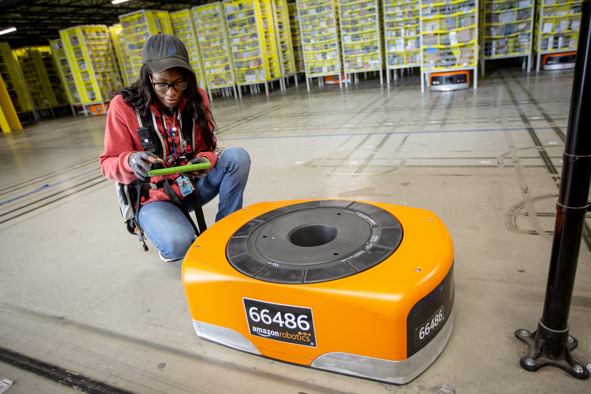 Amazon Robotics technician attends to a fulfillment center robot