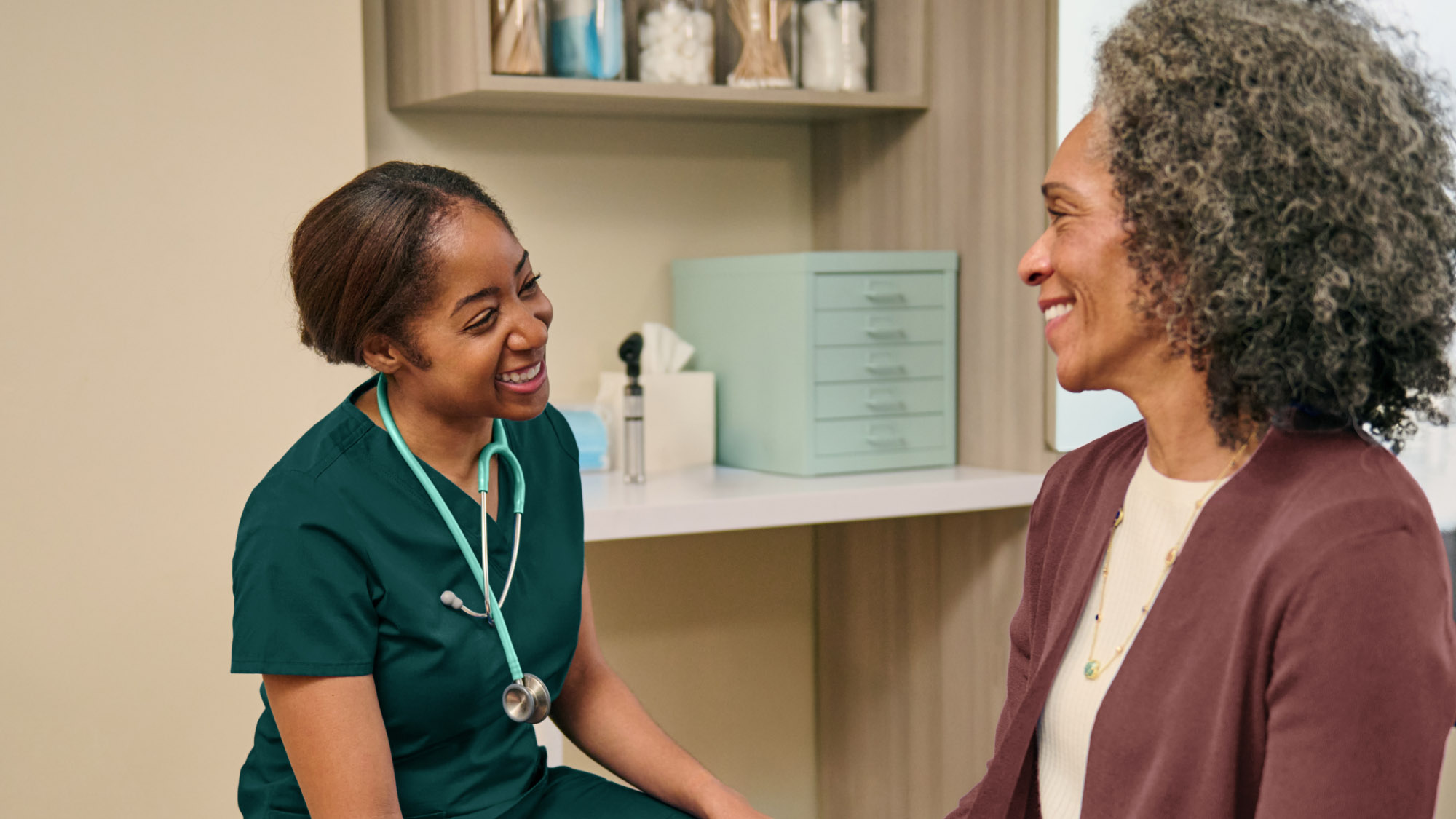 Healthcare professional and patient sharing a joyful moment during consultation