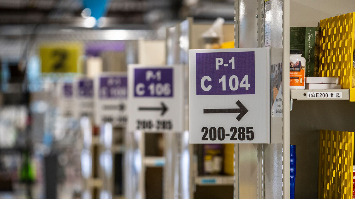 An image showing several rows of shelves with numerical and alphabetical organization inside Amazon's drone facility