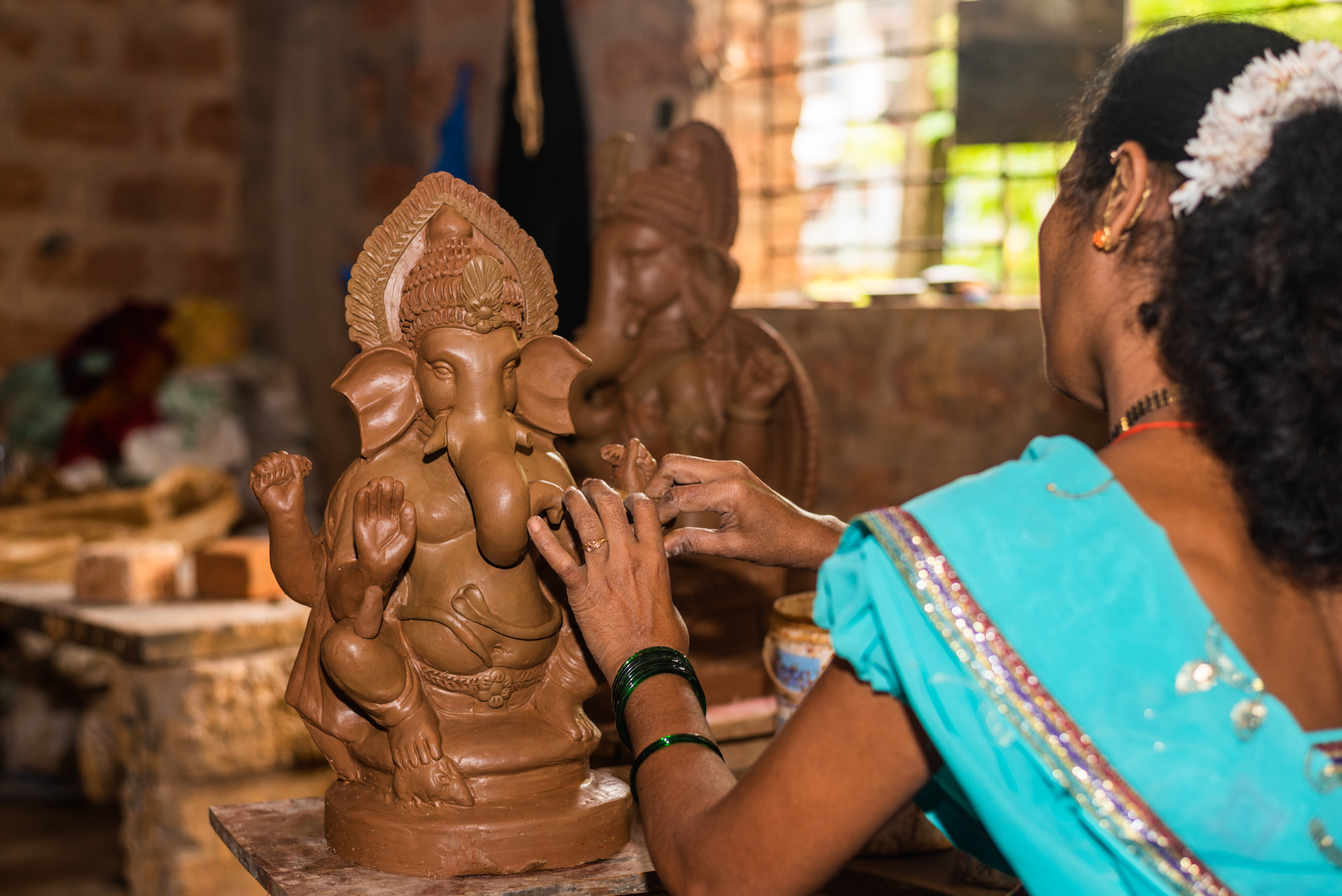 A lady making an eco friendly Ganesha