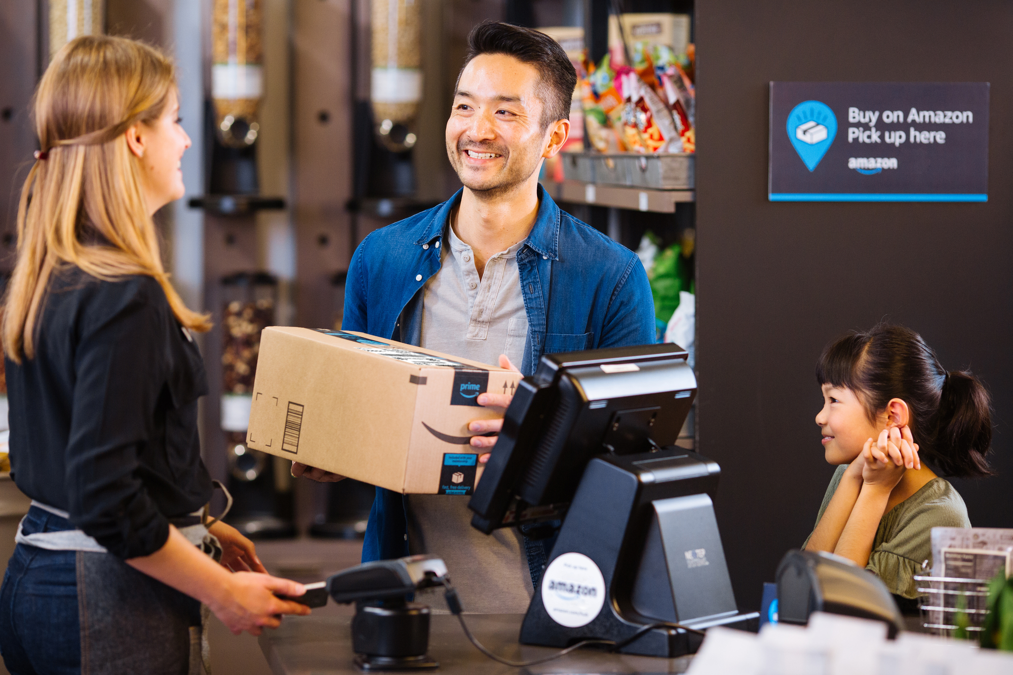 A smiling man receiving order from Amazon pickup location