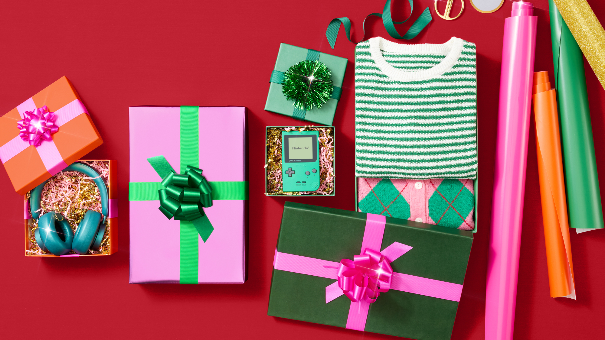 Colorful Christmas gifts and wrapping supplies on red background