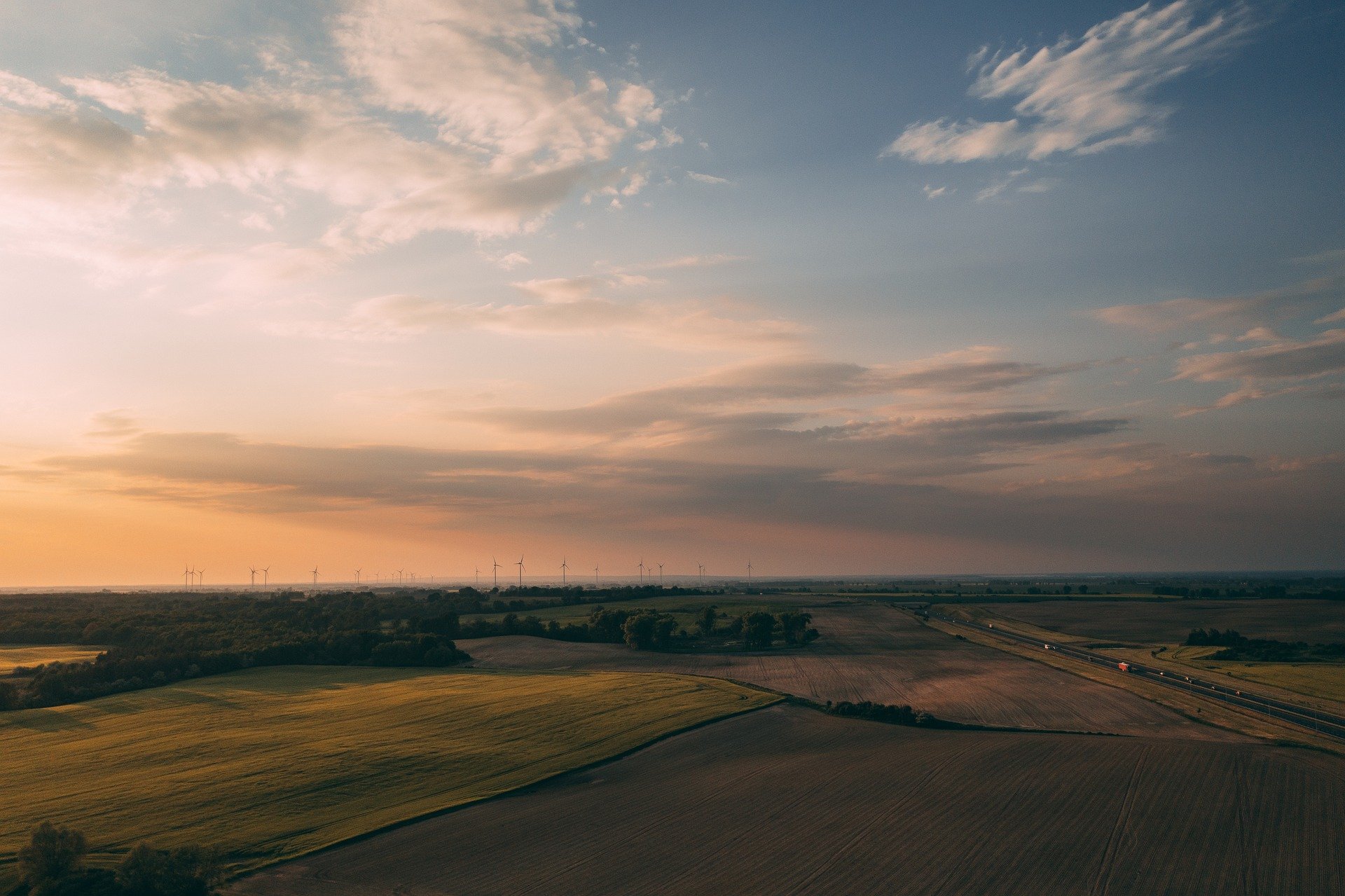 The Climate Pledge_Amazon_Felder im Sonnenuntergang_Windräder
