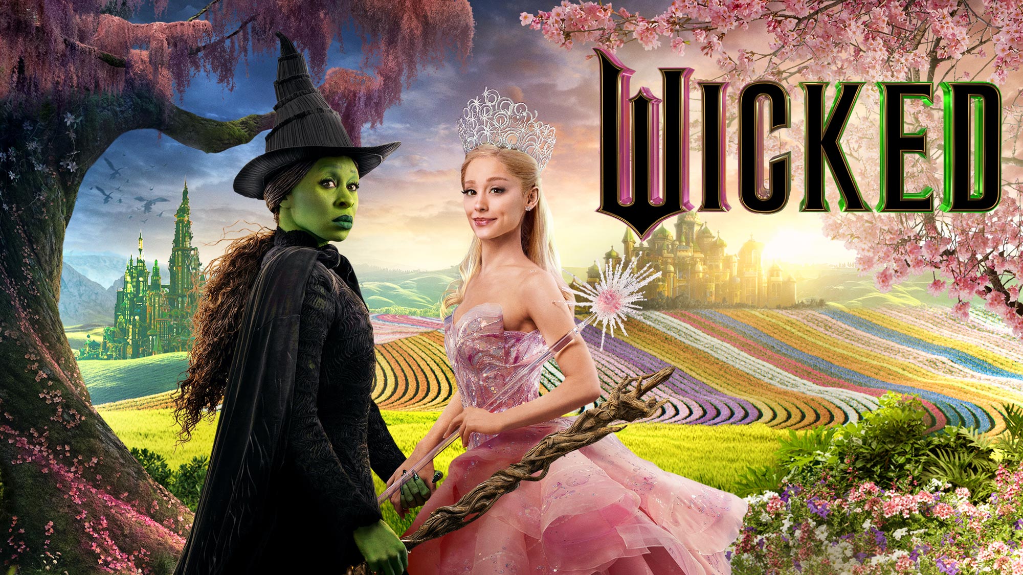 "Wicked" movie poster with Elphaba and Galinda with landscape of Oz in the background.