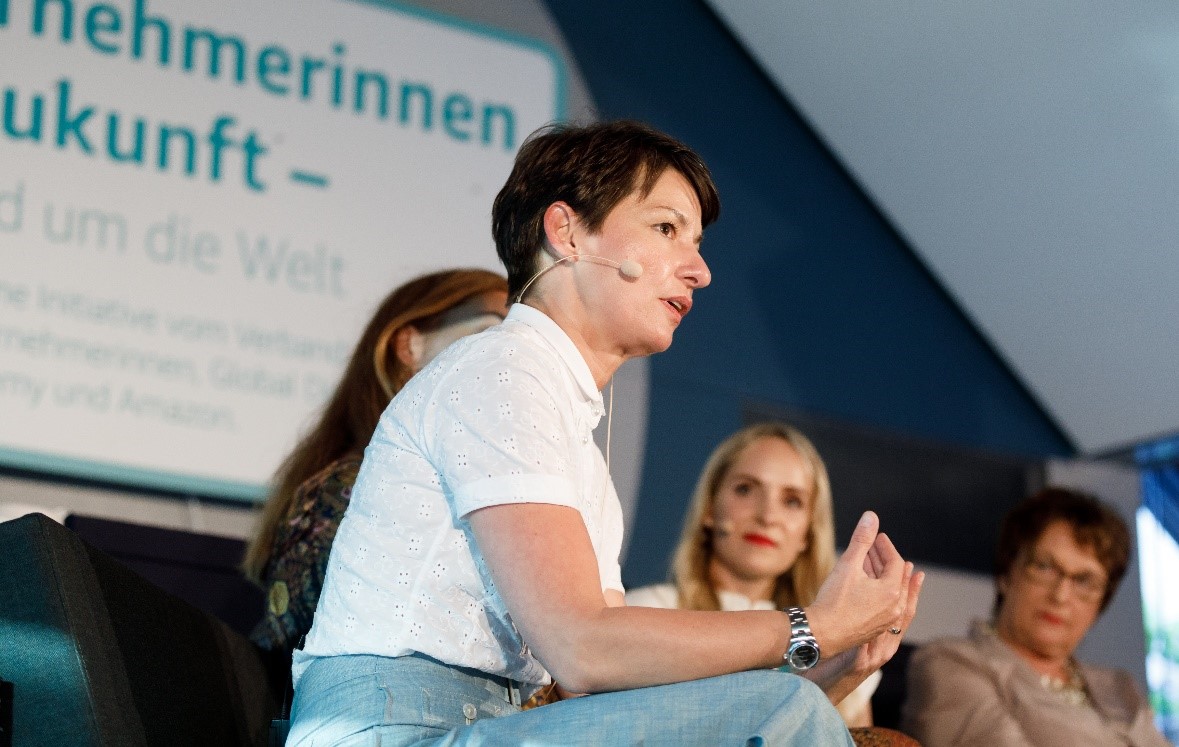 VDU-Präsidentin bei einer Podiumsdiskussion von Unterneherminnen der Zukunft. Im Hintergrund sieht man das Logo von Unternehmerinnen der Zukunft sowie die anderen Poduiumsteilnehmerinnen.