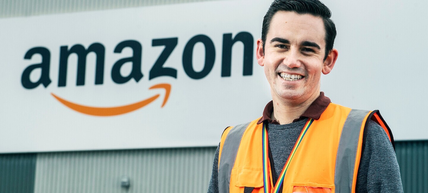 Amazon staff member in front of fulfilment centre