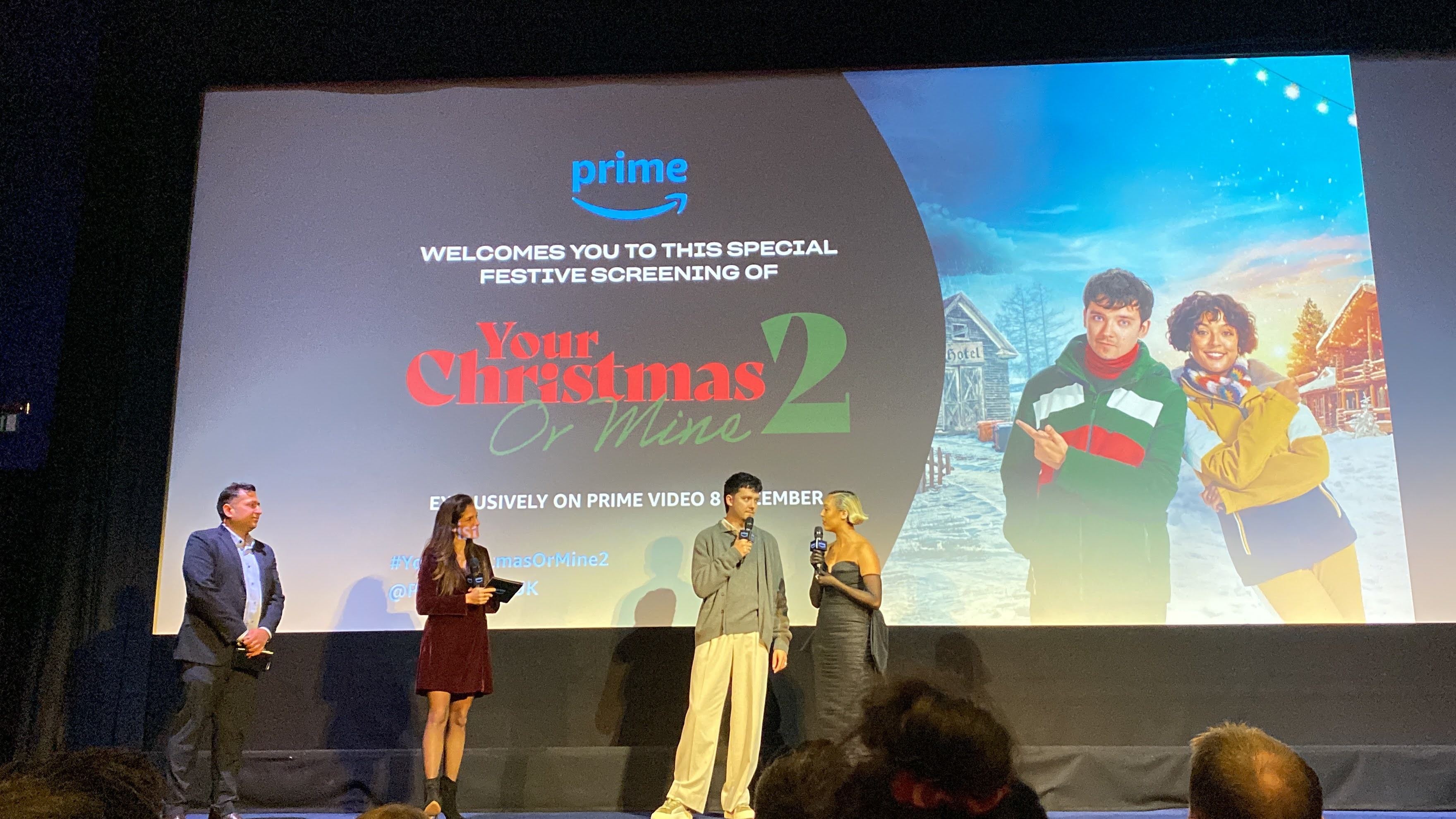 A large screen showing Your Christmas or Mine 2 with 4 people on stage