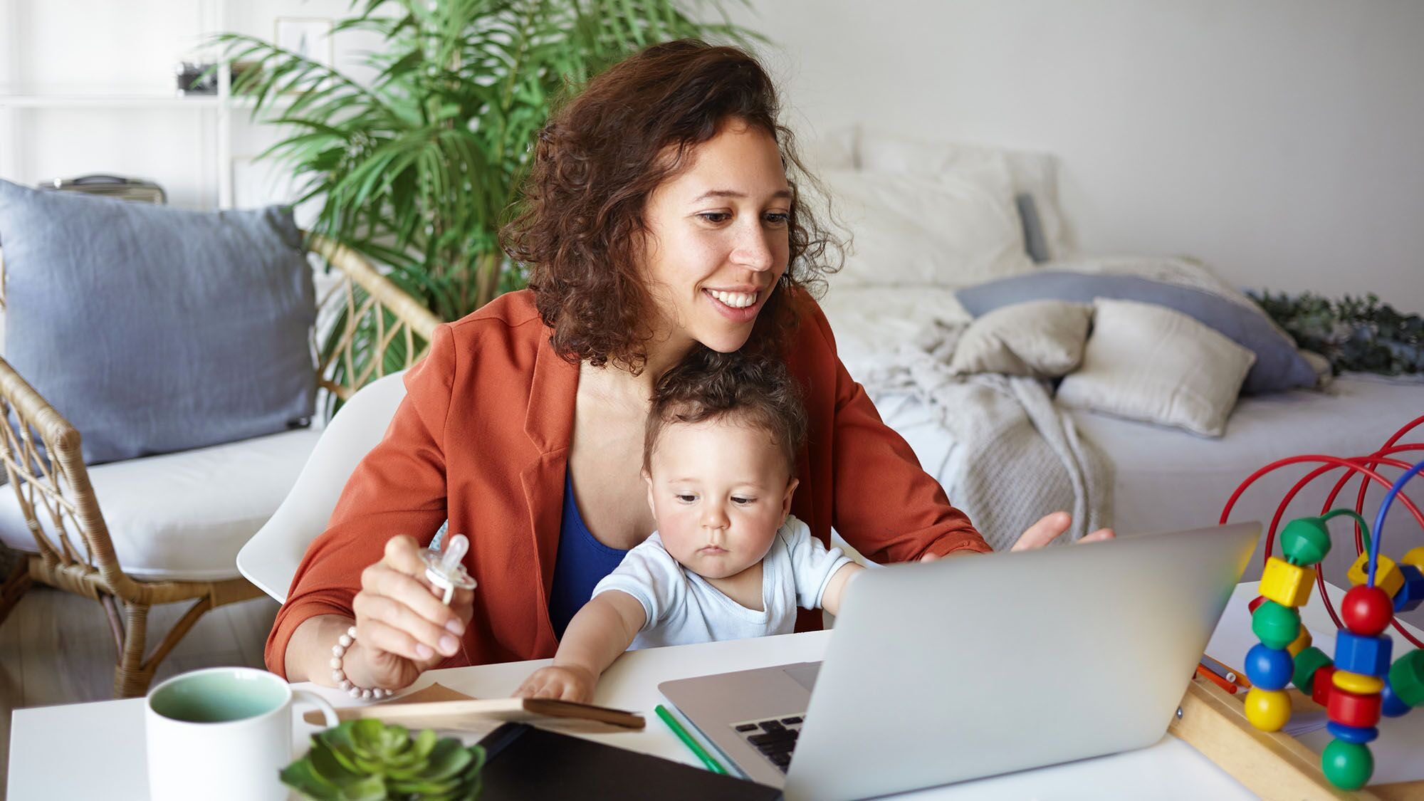 Mother with baby searching the Amazon.com on her laptop