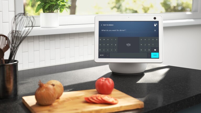 An image of an Echo Show device sitting on the kitchen counter showing the text to speech screen. There is a cutting board next to it with tomatoes and onions.