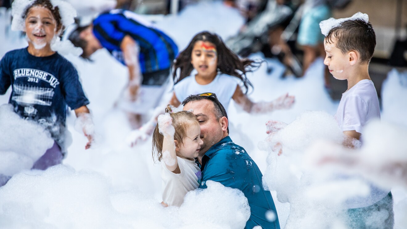 Amazon's HQ2 Community Day: children playing in bubbles and a father holding his daughter smiling