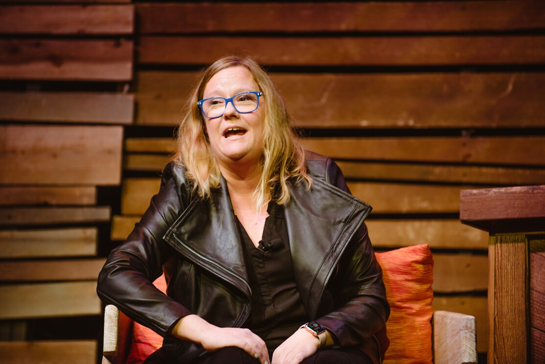 A woman, Becky Gansert, speaking to the crowd from the stage at Amazon "Live at the Ryman."