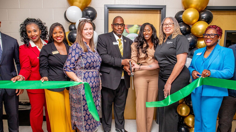 Diverse group of professionals at ribbon-cutting ceremony with balloons