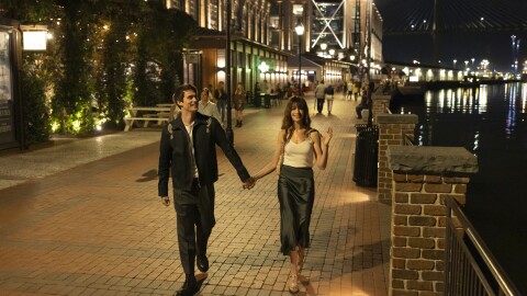 two people walking down the street holding hands