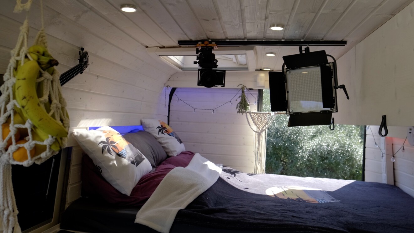 Innenansicht des Camper Vans mit Bett und Fernseher.