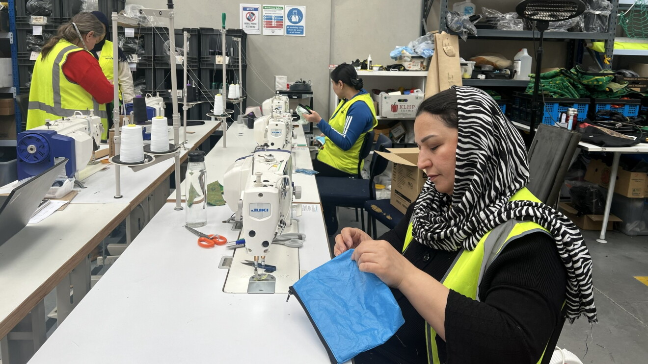 Image of a woman repurposing an Amazon delivery bag, sewing