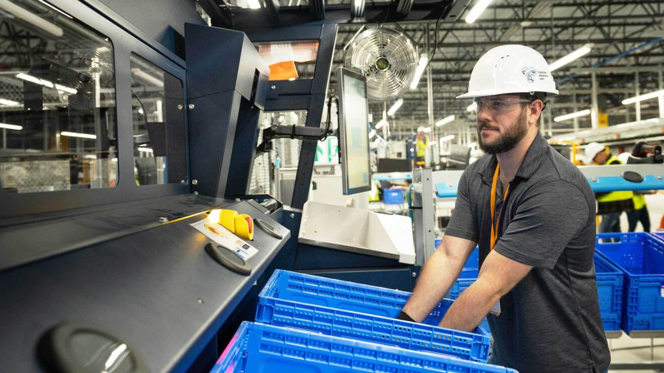 Image of an employee in a hard hat using the new robotic solutions that will support workplace safety at Amazon