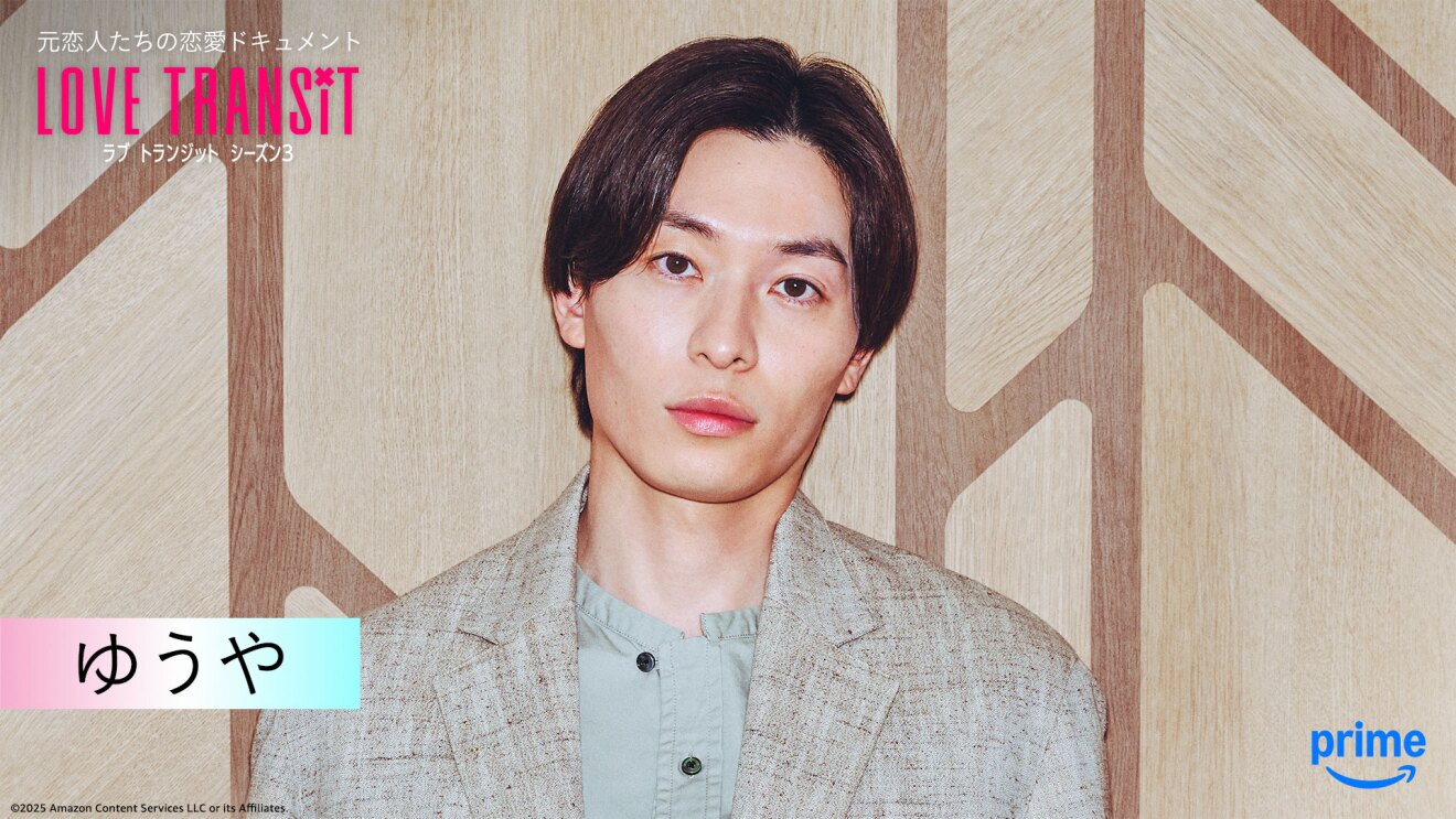 木目調の壁の前に立つ人物のバストアップ。左上隅に「LOVE TRANSIT」の文字。左下に「ゆうや」と名前が表示されている。