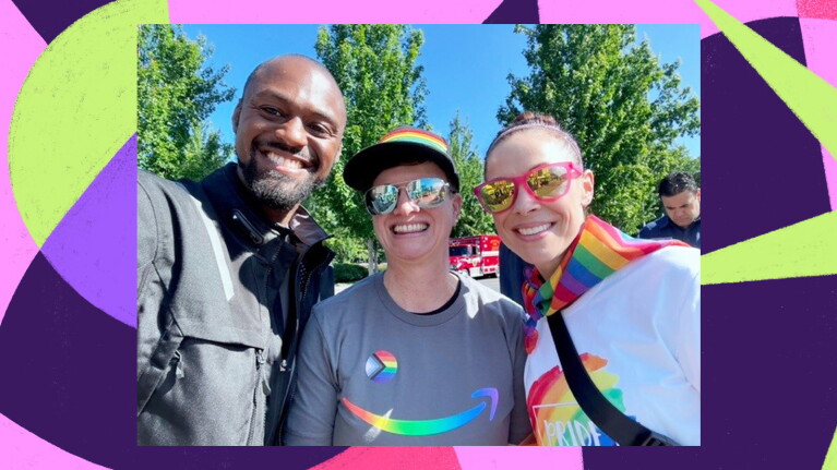 Three amazon employees smiling at the camera and wearing Pride swag. 