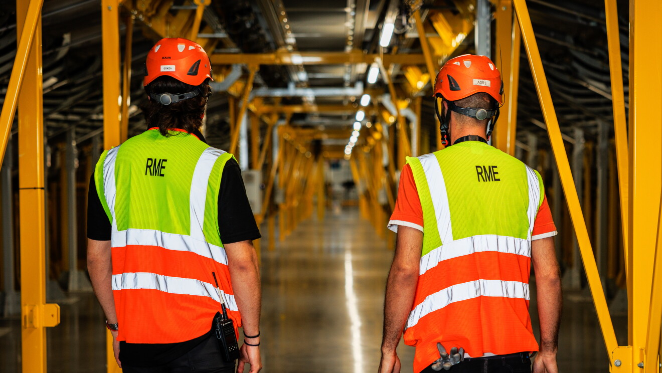 Dos hombres mirando un máquina en un centro logístico de Amazon.
