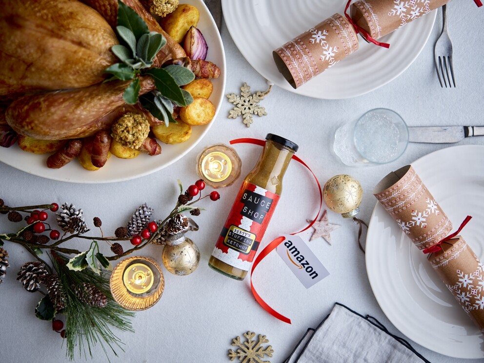 Sauce Shop Stuffing sauce on a dinner table with a Christmas turkey and plates with crackers and other decorations. 