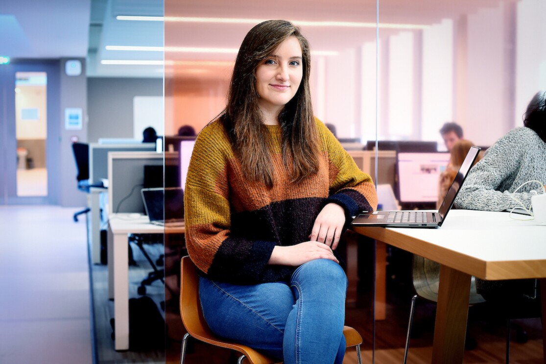 Robyn Greene an AFE Bursary awardee sitting at a table with a laptop next to her.