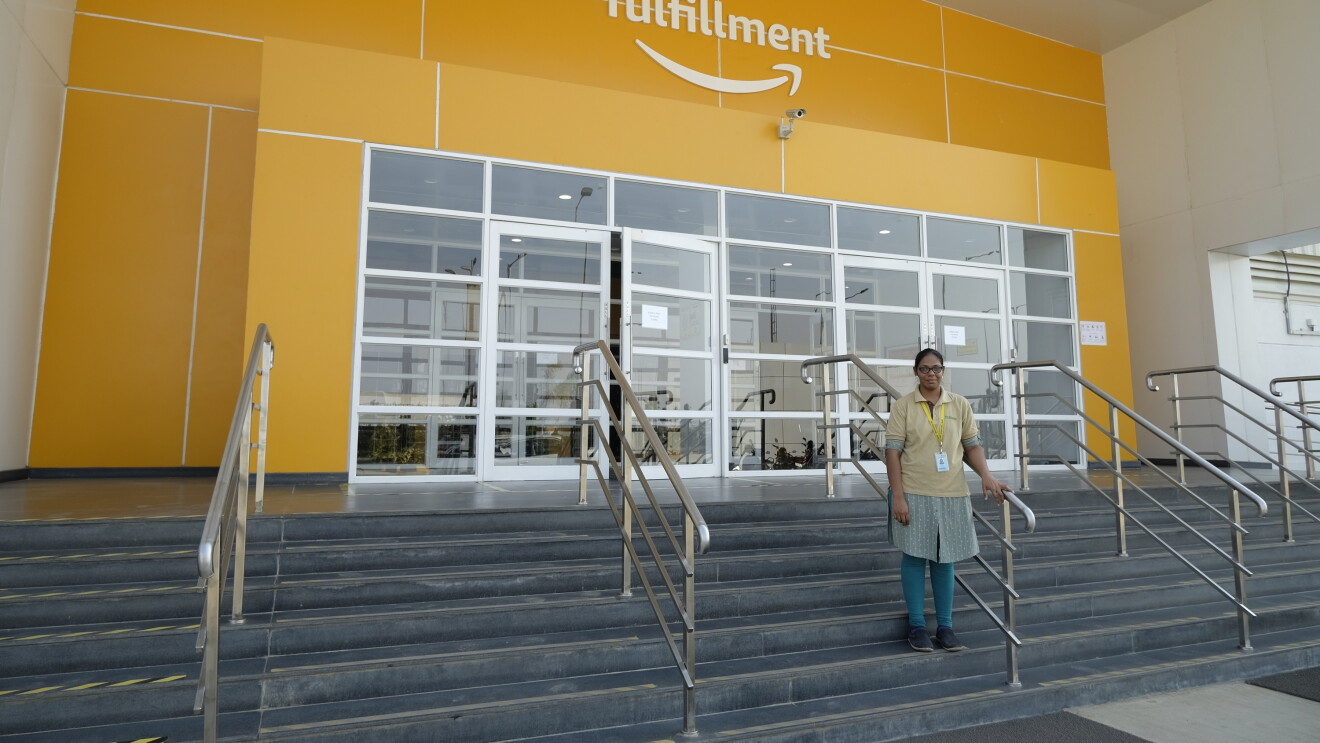 Merin, Amazon India's first forklift operator, stands on the steps that leads to the Fulfillment centre entrance
