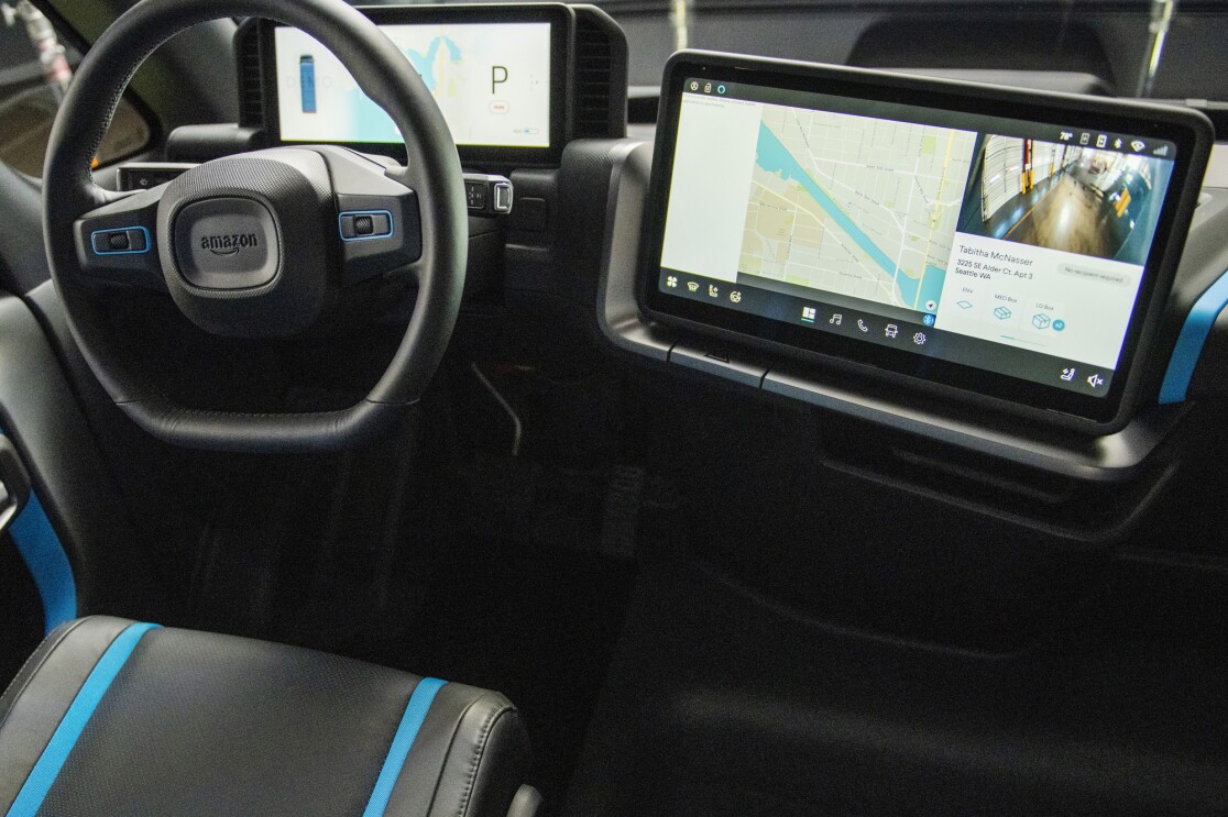 Digital displays and a steering wheel inside an Amazon electric delivery vehicle.