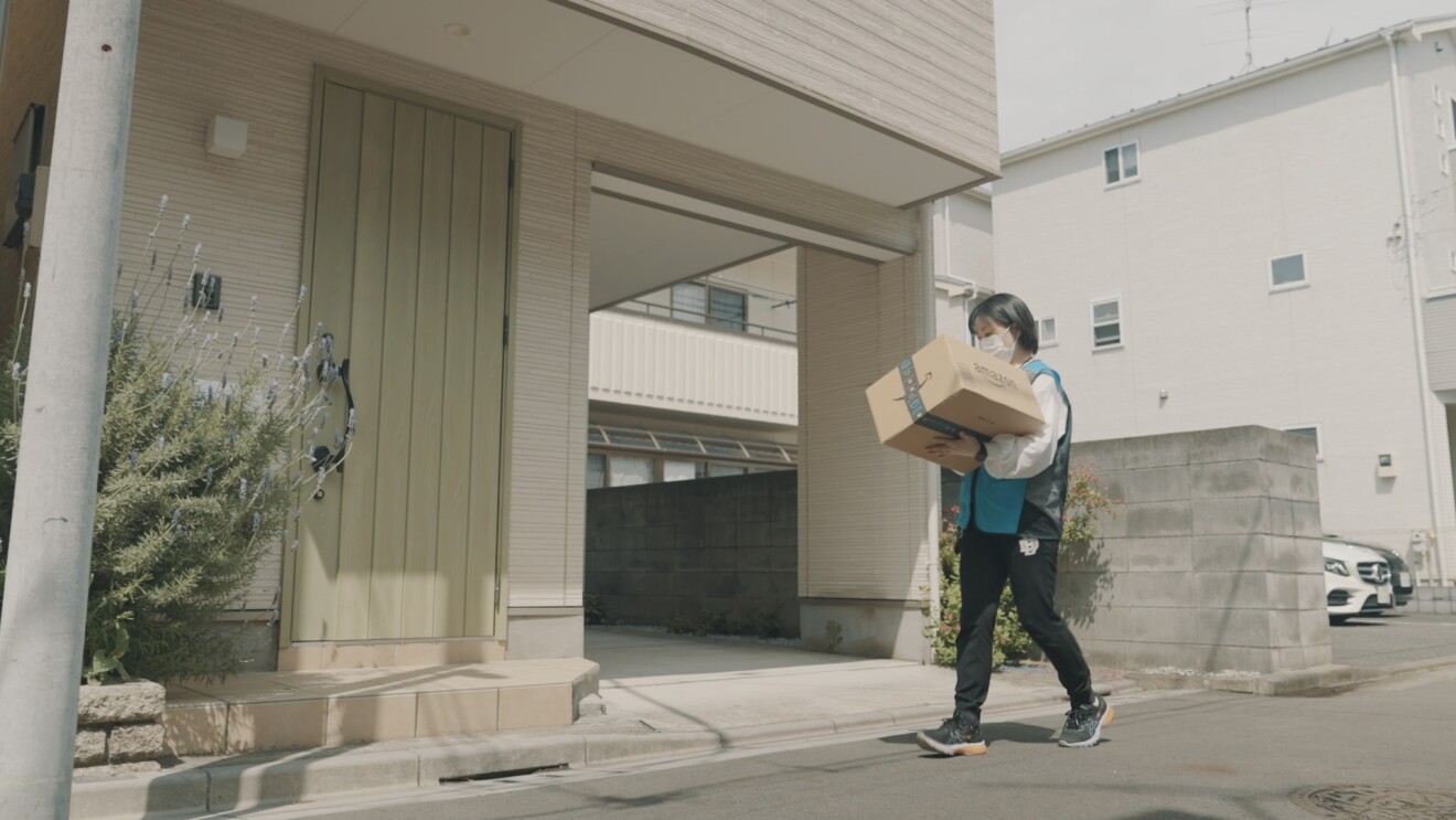 お届け先にダンボールを運んでいる写真