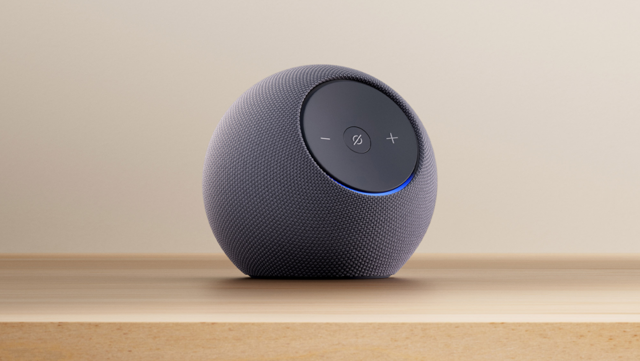 Amazon Echo Dot gris avec anneau lumineux bleu sur une table de couleur claire