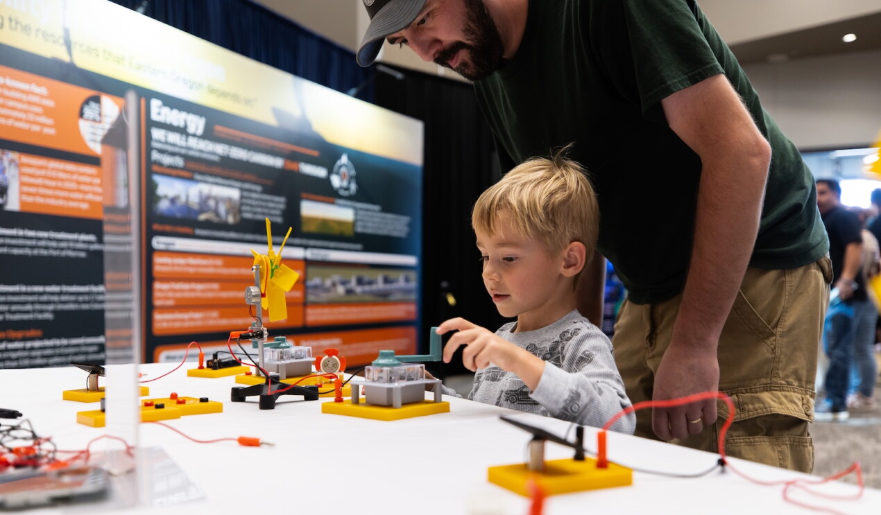 A parent and child engage with one of the creative stations at Amazon's Community Day
