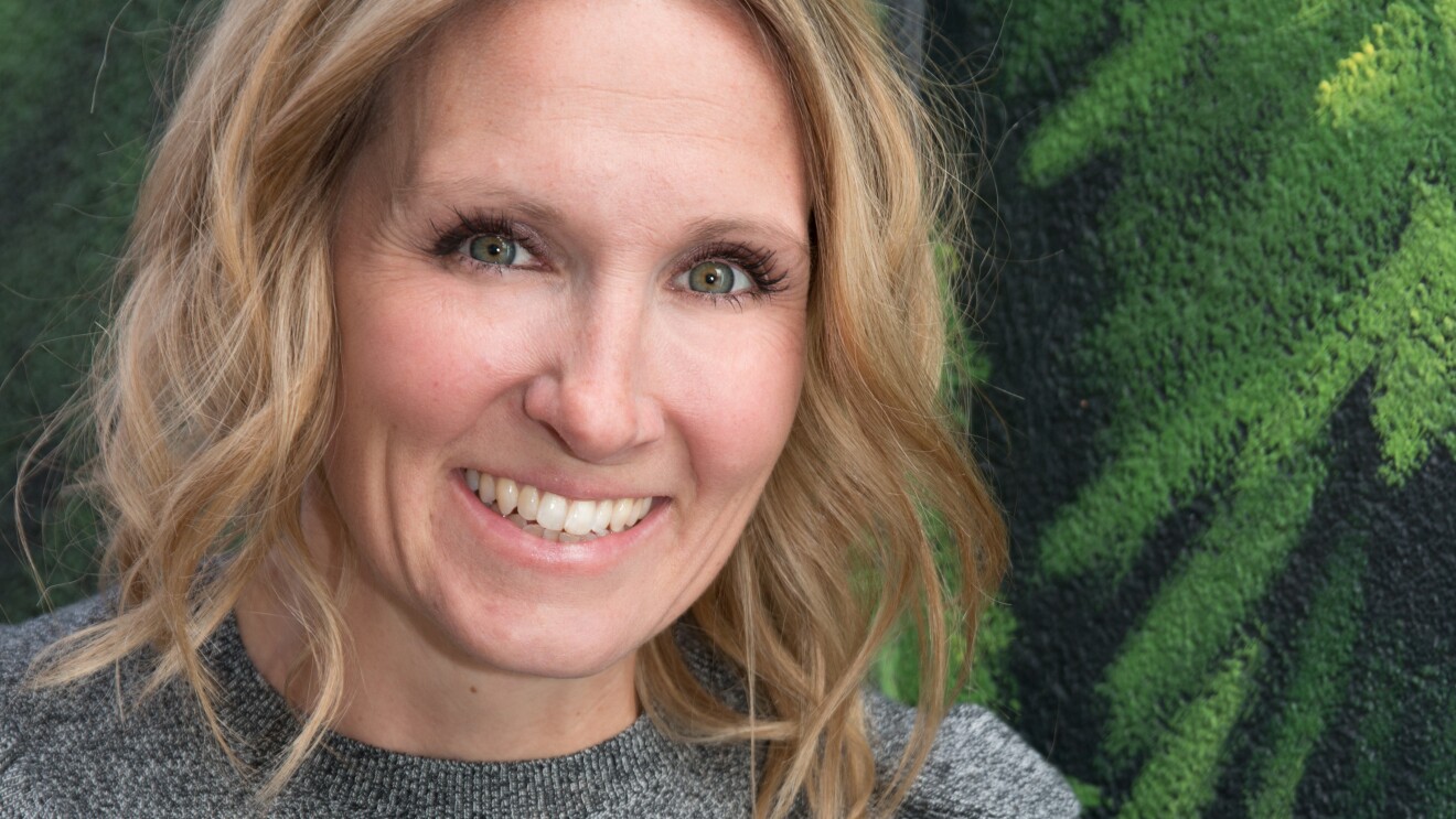 儿童读物作家丽贝卡·克兰的肖像。她穿着一件灰色长袖毛衣,有褶边,头发鬈曲