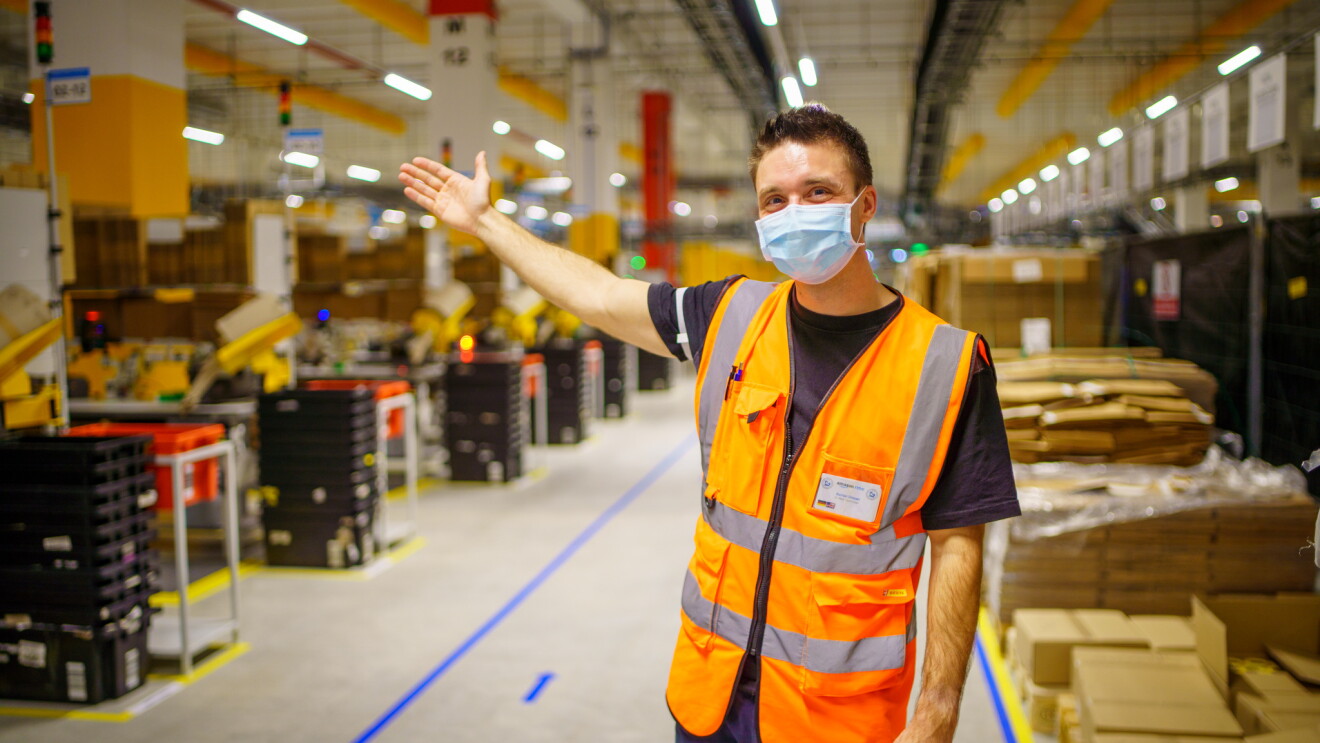 Bastian Dressel mit einem Willkommensgruß im Logistikzentrum.