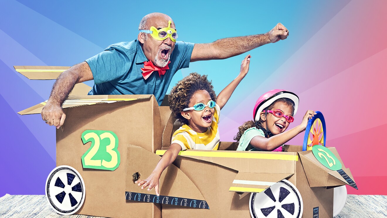 两个孩子,一个男人出现快乐的“骑”在一个纸箱车。